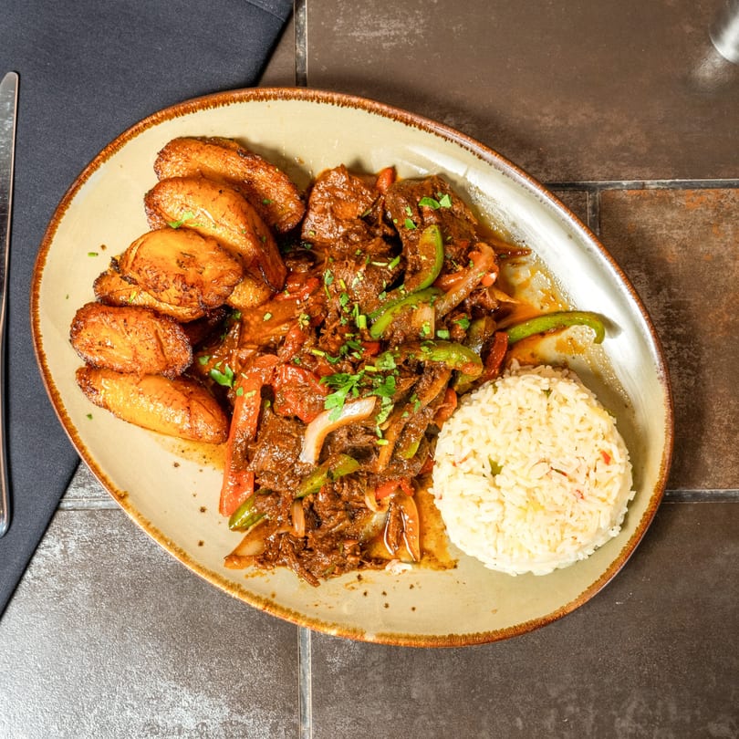 Cuban shredded beef with peppers and onions, served with fried plantains and white rice.