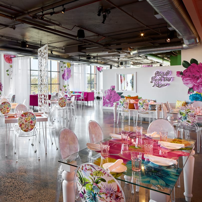 Havana 151's dining room features clear chairs, glass tables, and vibrant floral decor with pink accents.