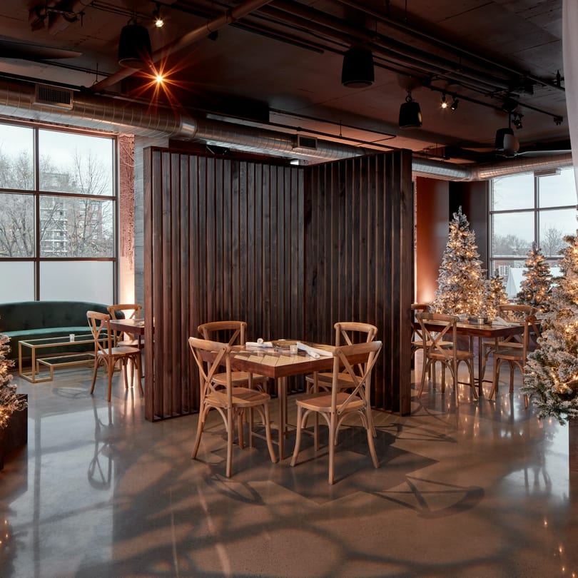 Havana 151's Loft dining area with wooden tables, chairs, and festive Christmas trees.