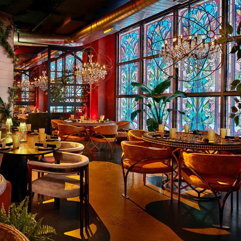 Havana 151 restaurant interior with ornate chandeliers, stained-glass windows, and velvet chairs.