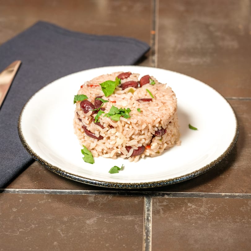 A serving of Havana 151's Cuban rice and beans, garnished with fresh parsley on a white plate.